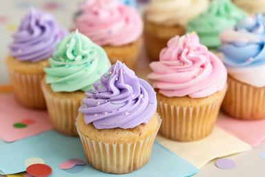 Mini cupcakes met zachte toefjes en eetbare glitters op een schooltraktatietafel